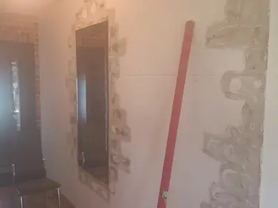 Montaż ciętej starej cegły dekoracyjnej na ścianie w korytarzu