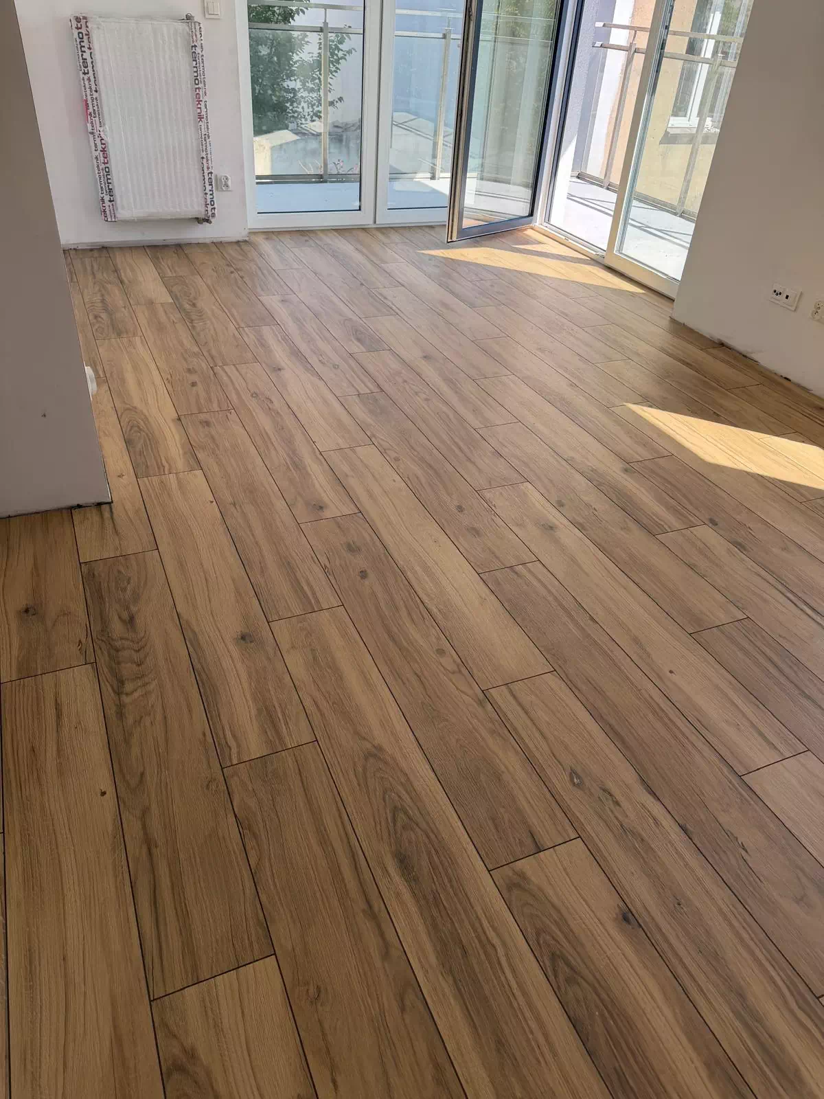 Płytki drewnopodobne ułożone na podłodze w salonie w Gnieźnie